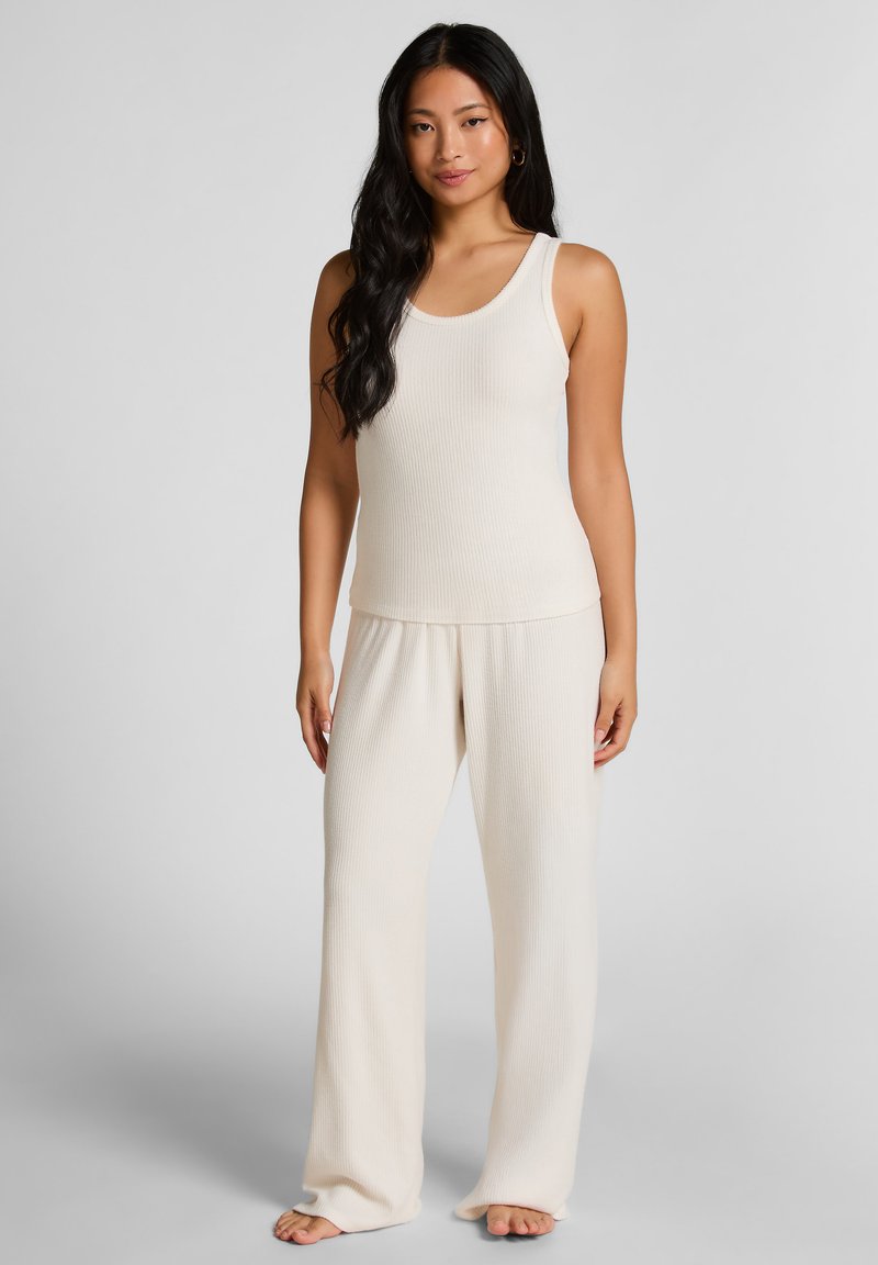 Ribbel gebreide tanktop en wijde broek set in zacht crème. Kenmerkt een ronde hals, een relaxte pasvorm en een zachte textuur voor comfort.