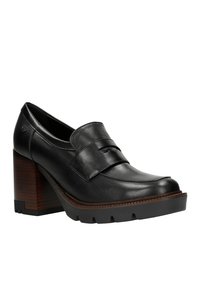 Scarpa con tacco in pelle nera, punta arrotondata, ampia fascia sul dorso del piede, tacco in legno testurizzato e suola in gomma con battistrada.