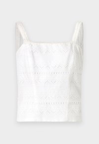 Camisole en coton blanc avec de fines bretelles, ornée de motifs brodés et de découpes. Texture lisse, design ajusté.