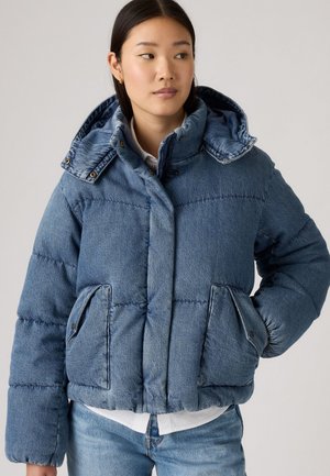 Denim pufferjack, lichtblauw, met een capuchon en drukknoopsluitingen. Beschikt over grote voorzakken en een gewatteerde textuur.