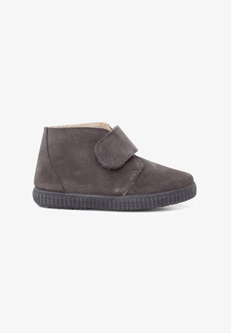 Dark gray suede children's shoe with a textured rubber sole and a single wide hook-and-loop strap for fastening.