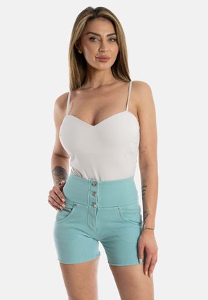 Weißes, tailliertes Bodysuit mit dünnen Trägern, kombiniert mit hochgeschnittenen, hellblauen Jeansshorts mit Knöpfen vorne und schrägen Taschen.