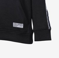 Sudadera negra con una etiqueta que dice "Kaporal Jeans". Presenta franjas laterales blancas y puños de canalé. Ajuste estándar y textura de tela.