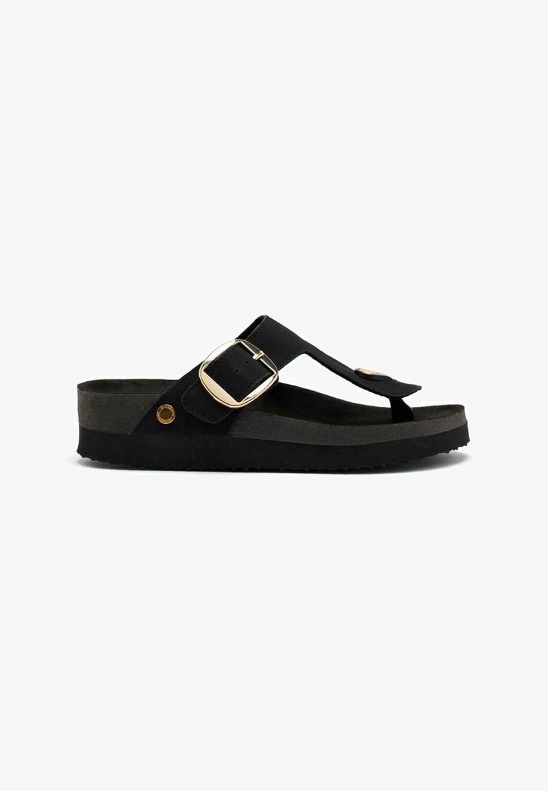 Chancla de ante negra con una correa ancha y un cinturón de metal tono dorado. Presenta una suela negra texturizada y un diseño minimalista.