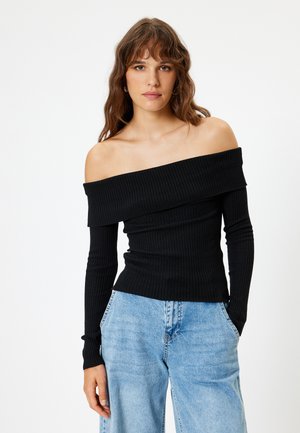 Schwarz, schulterfreies, geripptes Oberteil mit langen Ärmeln, tailliertem Schnitt und strukturiertem Stoff. Kombiniert mit hellblauen, weiten Jeans.