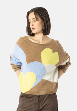 Maglione marrone a maglia con grandi motivi a cuore in giallo, blu e bianco, con scollatura ampia e vestibilità leggermente oversize.