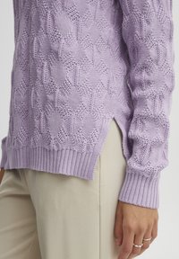 Maglione lilla lavorato a maglia con motivo a diamante testurizzato, polsini e orlo a costine, fessure laterali, abbinato a pantaloni beige. Tessuto morbido e design traspirante.