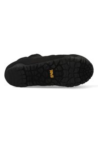 Black athletic shoe featuring a textured rubber outsole with a tree-like tread pattern and a prominent yellow Teva logo.
