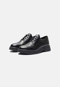 Black leather lace-up shoes with a textured finish, rounded toe, and a low, sturdy sole. Classic design suitable for formal settings.