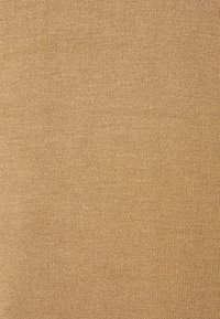 Teksturowana tkanina w ciepłym, ziemistym odcieniu beżowym z delikatnym wzorem dzianiny. Gładka powierzchnia o jednolitym wyglądzie, idealna do różnych zastosowań.