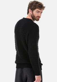 Schwarzer gestrickter Pullover mit einem strukturierten Rautenmuster. Verfügt über einen rund ausgeschnittenen Ausschnitt sowie gerippte Bündchen und Saum, die eine figurbetonte Silhouette bieten.