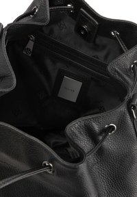 Black leather bucket bag featuring a textured exterior, drawstring closure, and interior zip pocket. Lined with black fabric and logo print.