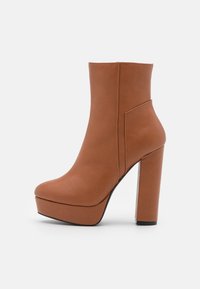 Hnědá faux kožená kotníková bota s vysokým blokovým podpatkem, platformovou podrážkou a elegantním, štíhlým designem. Hladká textura bez viditelných vzorů.