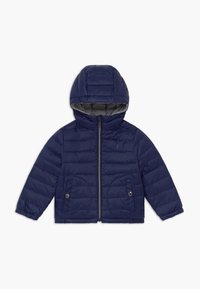 Marinblått puffjacka med huva, dragkedjestängning och två framfickor. Kviltad textur med en slät yta. Grå inre foder.