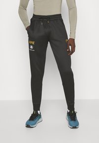 Venum - UFC FIGHT NIGHT ADRENALINE JOGGERS - Spodnji deli trenirk - black/gold Miniaturna slika 1