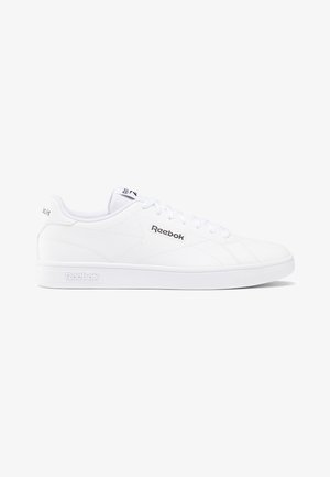 Valkoiset Reebok-tennarit, jotka on valmistettu sileästä nahasta, ympyräpäisellä kärjellä, litteällä kumipohjalla ja huomaamattomalla brändäyksellä sivussa ja kielessä. Nauhakuosiset.