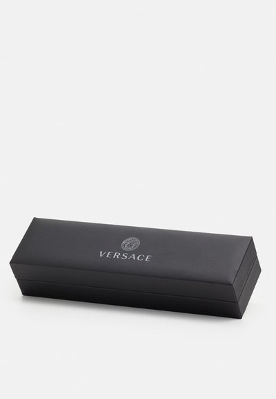 Boîte rectangulaire noire en matériau texturé avec un couvercle, arborant le logo "VERSACE" et un emblème de méduse sur le devant.