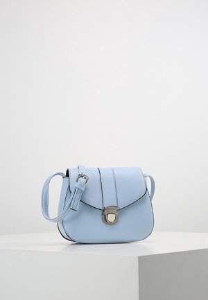 Lichtblauwe leren crossbodytas met verstelbare band en zilveren sluiting, geplaatst op een witte ondergrond tegen een effen achtergrond.