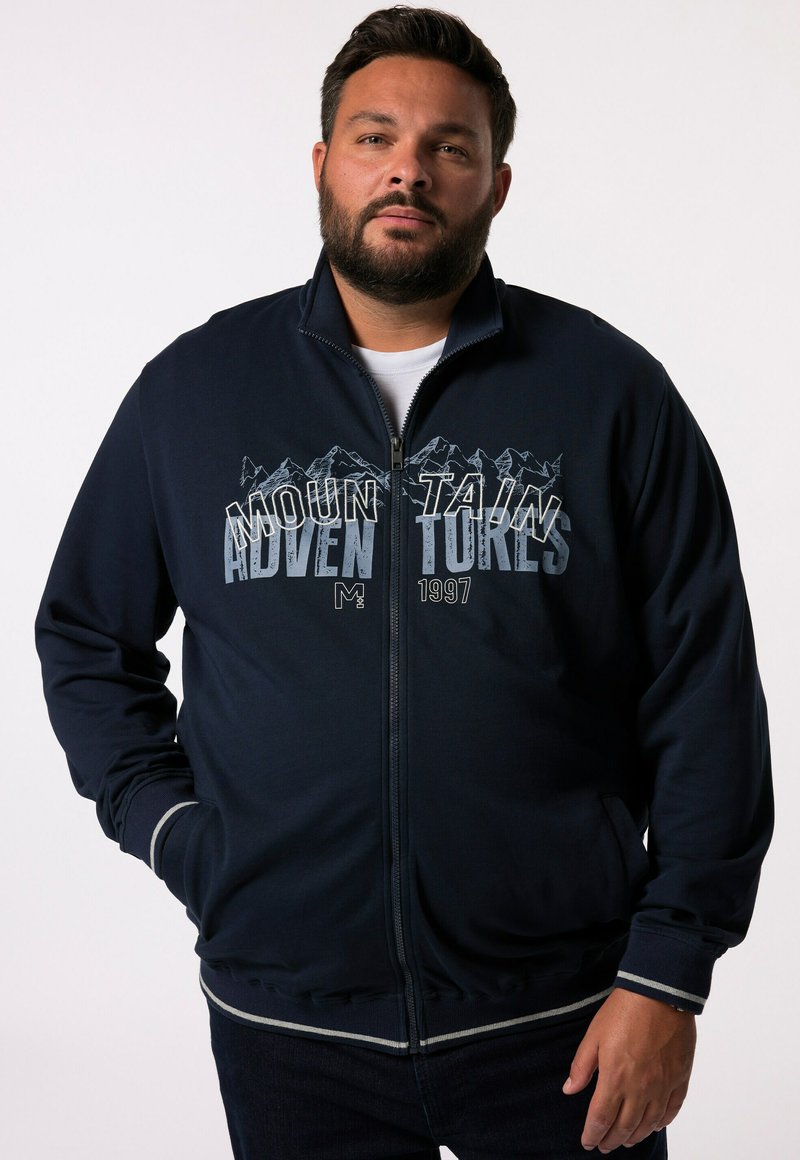 Navy zip-up jacket with mountain graphic and "ADVENTURES" text. Features ribbed cuffs and hem with light gray stripes. Smooth fabric texture.