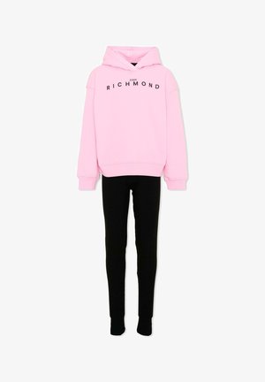 Roze hoodie met "John Richmond" tekst gecombineerd met zwarte aansluitende broek, weergegeven op een witte achtergrond.