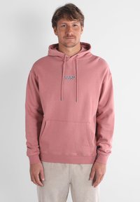 Hoodie in cotone rosa con tasca frontale, cappuccio con lacci e ricamo del logo. Presenta polsini e fondo a coste, texture morbida.