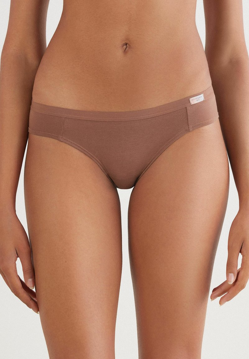 Bruine stretch katoenen bikini met een gladde textuur, een lage taille en minimale naden, en voorzien van een klein label op de tailleband.