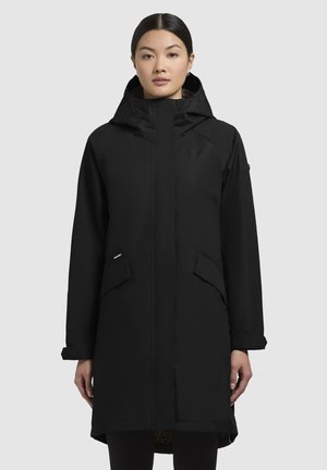 Parka noir imperméable avec capuche, manches longues, deux poches à l'avant et fermeture zippée. Dotée d'une doublure intérieure texturée.