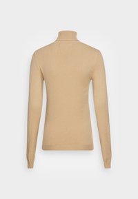 Tannfärgad polotröja i mjukt stickat material, med lång ärm, ribbad krage och figurformad silhuett.