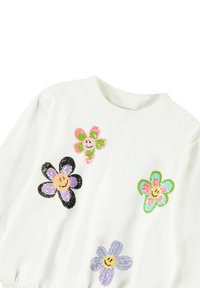 Witte sweatshirt met kleurrijke geborduurde bloemenontwerpen in roze, groen, paars en zwart met smiley gezichten. Textuuraccenten overal.