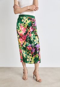 Květinová plisovaná sukně v jasných zelených, růžových a fialových odstínech, s volánkovým detailem na boku a zeleným pasem.