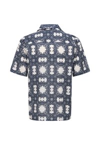 Chemise à manches courtes avec motif géométrique et floral de type carreaux bleu marine et blanc, vue de dos.