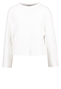 Vit ribbad långärmad topp med rund halsringning och kortad nederkant, med en texturerad tyg och avslappnad passform. Ingen synlig hårdvara.