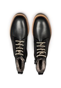 Bottines en cuir noir avec des lacets beige clair, une doublure en fourrure douce et une semelle contrastante couleur tan. Elles disposent d'une fermeture éclair sur le côté pour un enfilage facile.