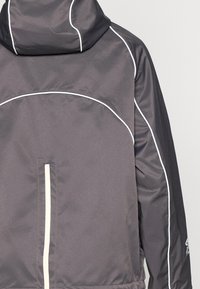 Gray windbreaker jacket with white piping detail, high collar, front zip, and smooth texture. Features seams that define the shape.
