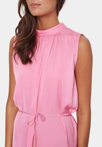 Vestido sin mangas de color rosa con un escote alto, diseño plisado y una característica de lazo en la cintura. Fabricado con un tejido suave y ligero.