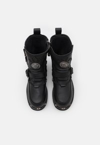 Botas de cuero negras con doble cremallera, correas ajustables, acentos con patrón de llamas y herrajes metálicos. Forro interior suave.