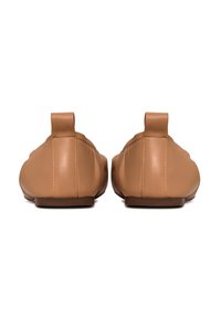 Zapatos slip-on de cuero marrón con punta redondeada, diseño minimalista y tacón bajo. Con un tirador en la parte trasera para facilitar su uso. Textura suave.