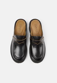 Scarpe slip-on in pelle nera con una texture liscia, caratterizzate da una soletta interna marrone in contrasto e da un delicato ricamo decorativo sulla tomaia.