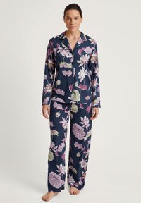 Marineblauw bloemendessin pyjama set met lange mouwen en rechte broekspijpen. Bevat roze en groene bloemenpatronen op zachte stof.