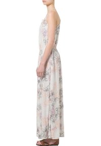 Robe longue sans manches en tissu léger, présentant un motif floral en rose pastel, violet et noir sur un fond blanc.