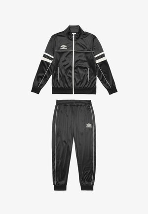 Černý teplákový komplet se zipovou bundou a kalhotami s elastickým pasem. Vyrobeno z lesklého materiálu, s bílými pruhy a akcenty loga.