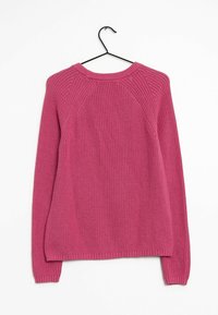 Różowy sweter z dzianiny na wieszaku, z teksturowanym wzorem, rękawami raglanowymi oraz prążkowanymi mankietami i dołem.