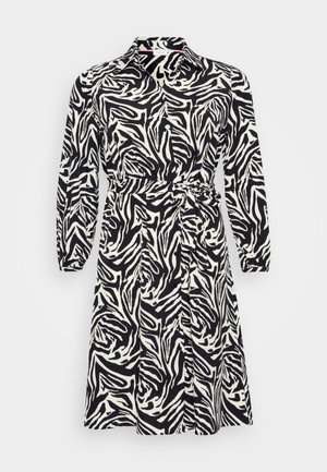 Pikendusvarrukatega kleit must-valge leopardi mustriga, kraega ja vöödiga taljes. Valmistatud siledast ja kergest kangast.