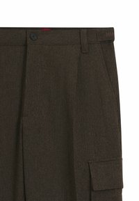 Bruna herringbone-byxor med flat front, sidofickor och knappstängning, tillverkade i en strukturerad ullblandning.