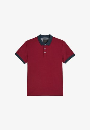 Czerwona koszulka polo z fakturowanym wzorem, granatowym kołnierzykiem i mankietami na rękawach, zapięciem na trzy guziki oraz małą metką marki na dole.