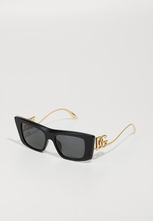 Black rectangular sunglasses with dark lenses. Gold metal arms feature a double 'G' logo accent. Smooth plastic frame.