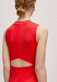 Rotes, geripptes, ärmelloses Oberteil mit einem Cut-out-Detail an der Rückseite. Glatte Textur mit einer taillierten Form und hohem Ausschnitt.