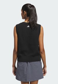 Czarny dzianinowy top bez rękawów z prążkowanym wykończeniem i teksturowanym wzorem, z białym logo Adidas z tyłu przy linii szyi.