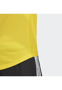 Gul atletisk trøje lavet af åndbart mesh-stof, med en afrundet kant og sømløse sidelapper for komfort.