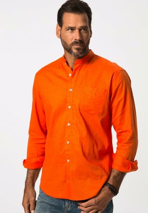 Orange linen shirt with a band collar, front pocket, and button-down design. Long sleeves are rolled up, displaying a casual look.